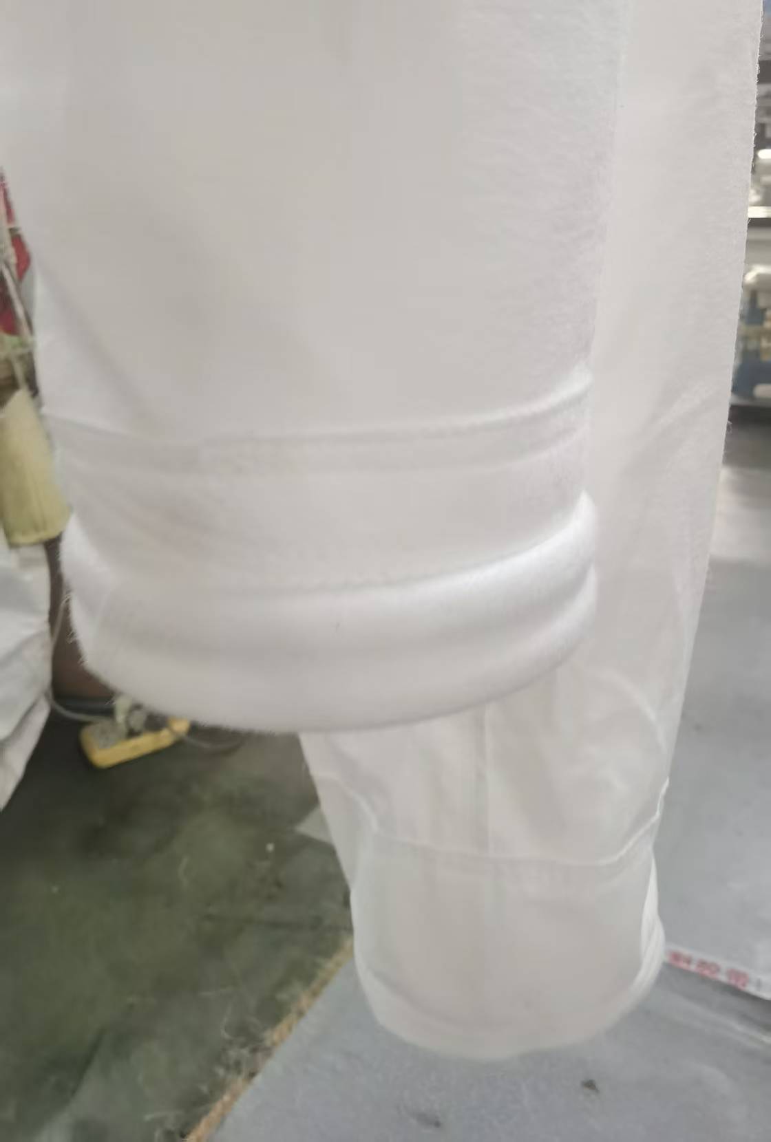 Custom 750 GSM PTFE filter bags with reinforced top sections during production